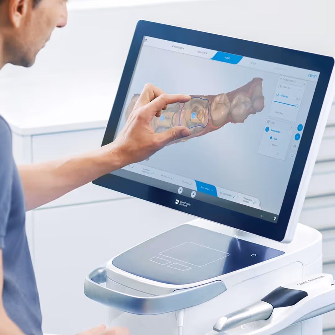 Dentist reviewing a 3D digital model of a patient's lower jaw on a CEREC CAD/CAM design workstation