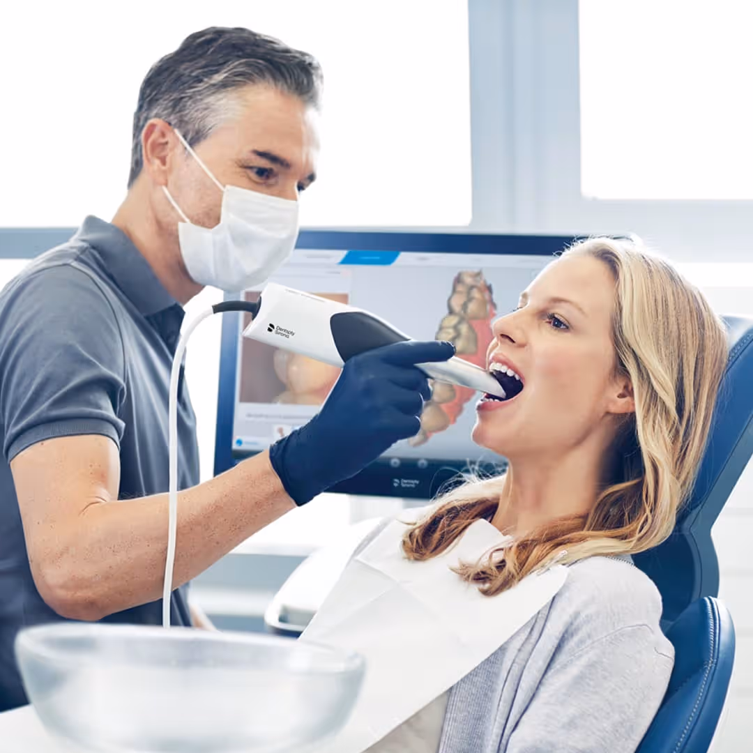 Dentist using a Dentsply Sirona intraoral scanner to take a digital impression of a patient's teeth